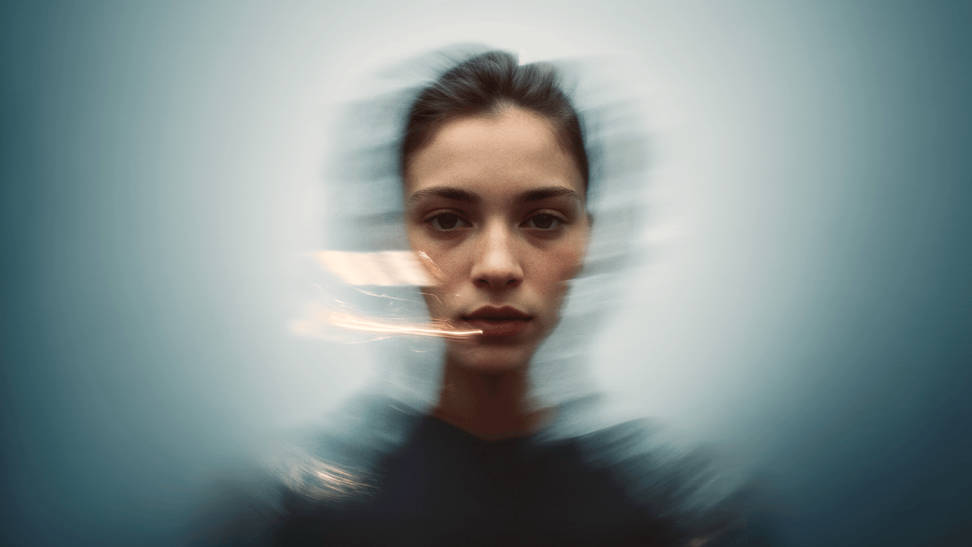 A woman's face in focus with a blurred, abstract motion effect surrounding her, creating a sense of movement and depth. A woman's face in focus with a blurred, abstract motion effect surrounding her, creating a sense of movement and depth.