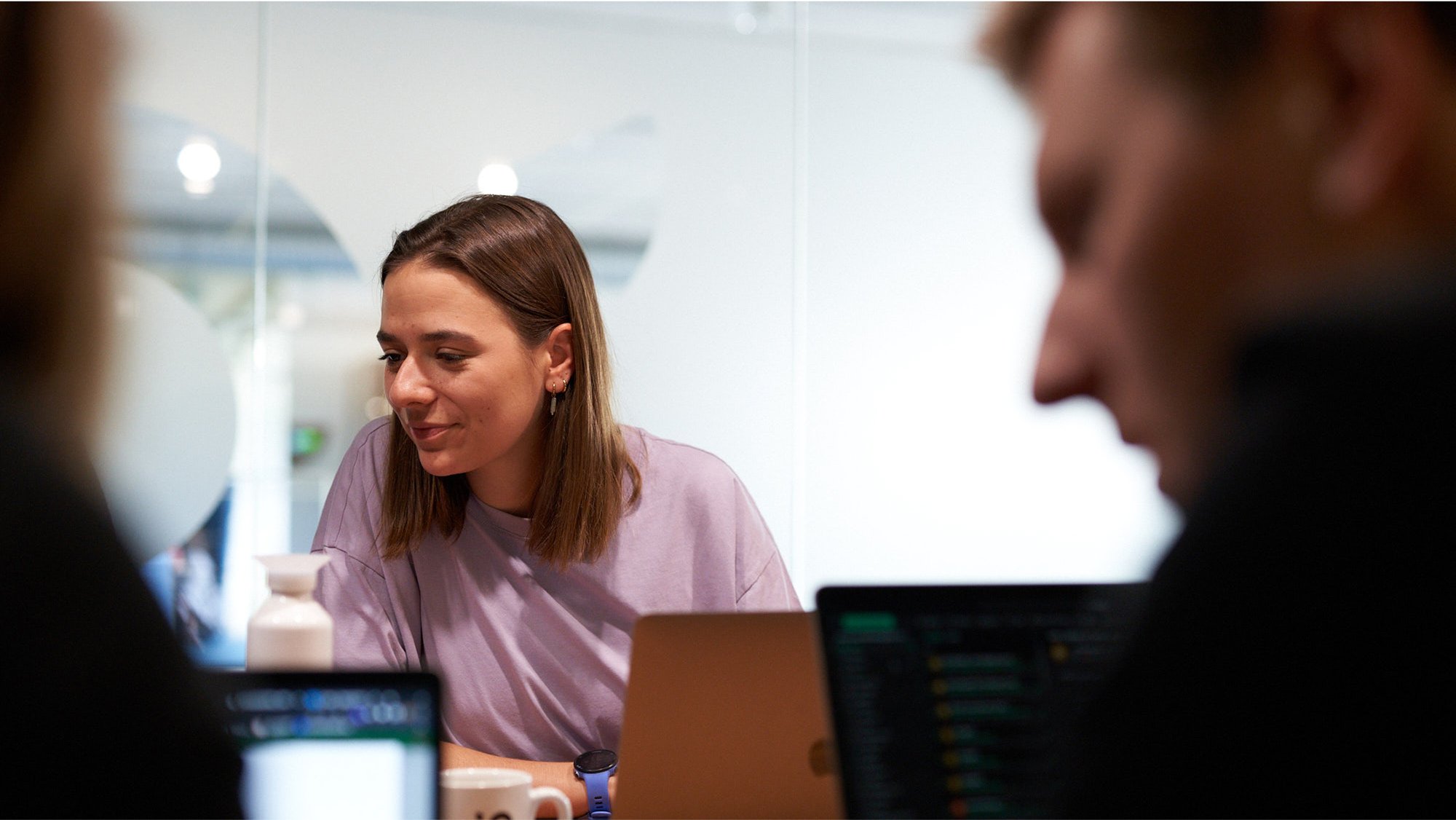 Woman engaged in discussion with colleagues during office meeting Woman engaged in discussion with colleagues during office meeting