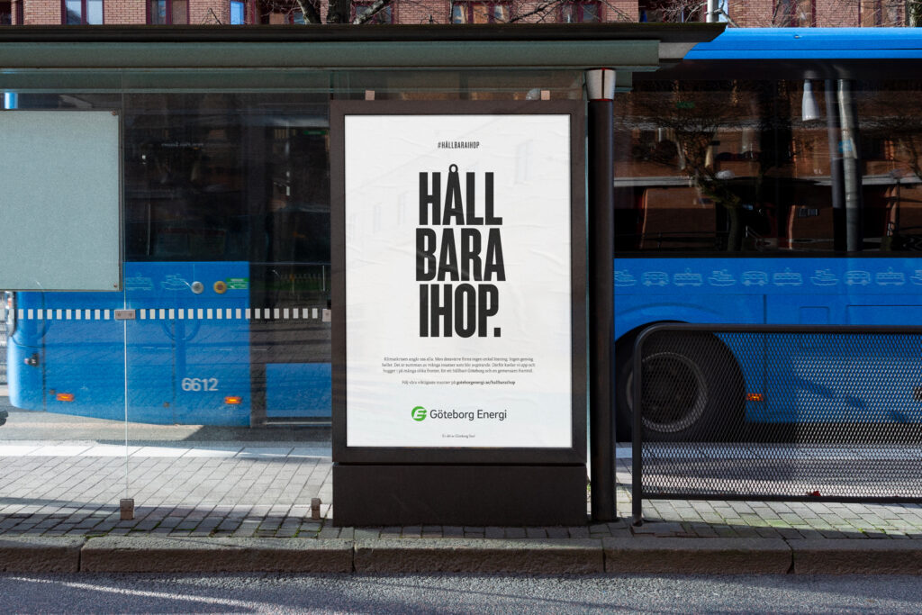 Bus stop poster reading 'Håll Bara Ihop' with a blue bus in the background; Göteborg Energi branding visible.