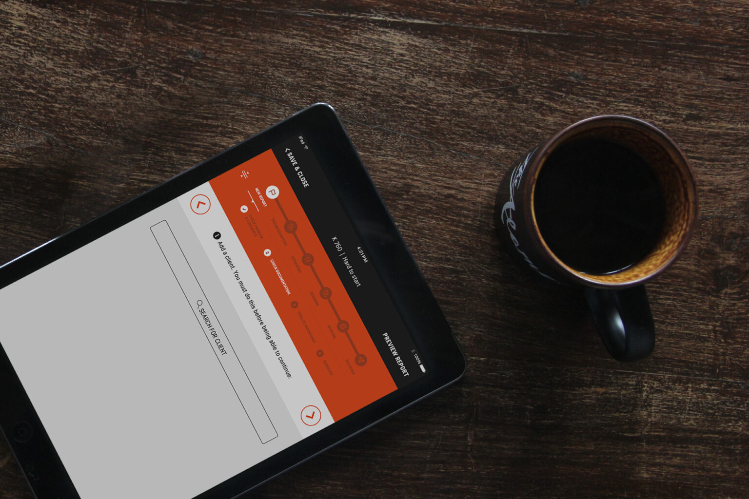 Tablet displaying a progress tracker next to a mug of black coffee on a wooden table.