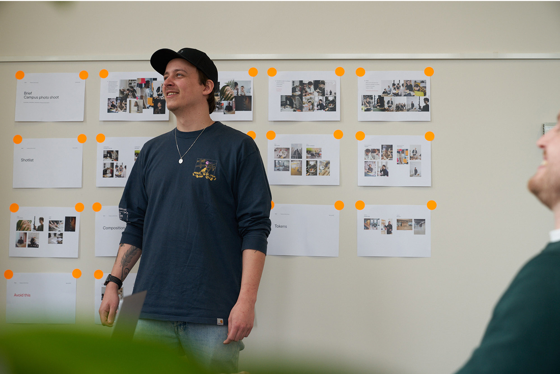 Creative presenting project with mood boards on wall during team meeting