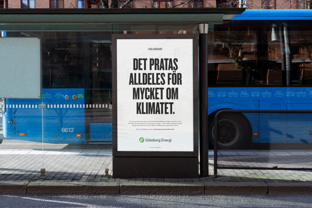 Bus stop advertisement in Swedish reads, 'Det pratas alldeles för mycket om klimatet,' with a blue bus visible behind it.