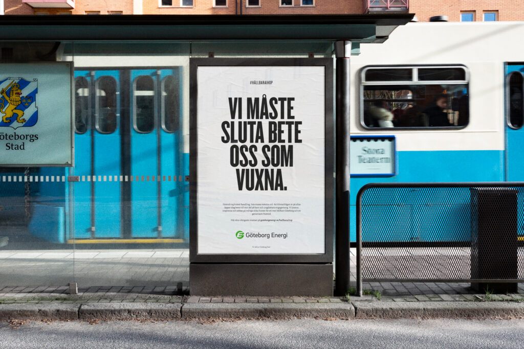 Bus stop ad reads, 'Vi måste sluta bete oss som vuxna' (We must stop acting like adults) with a tram passing behind.